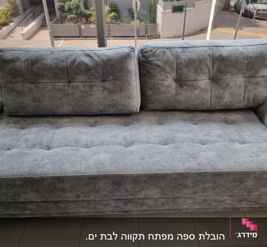ספה אפורה עם כריות גדולות בחלל פנימי